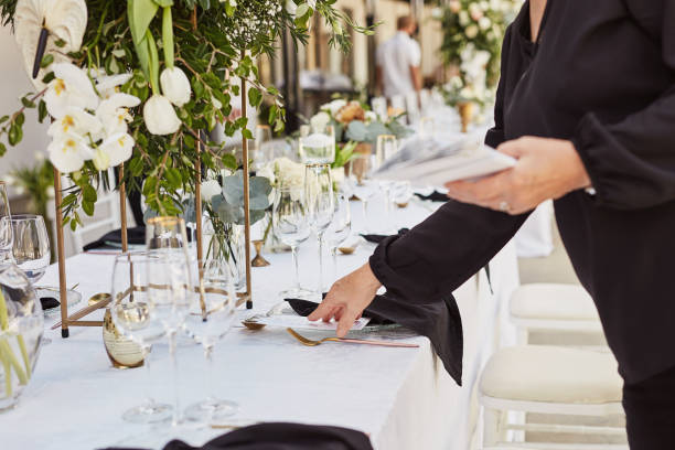 A wedding vendor setting a reception table at a wedding.