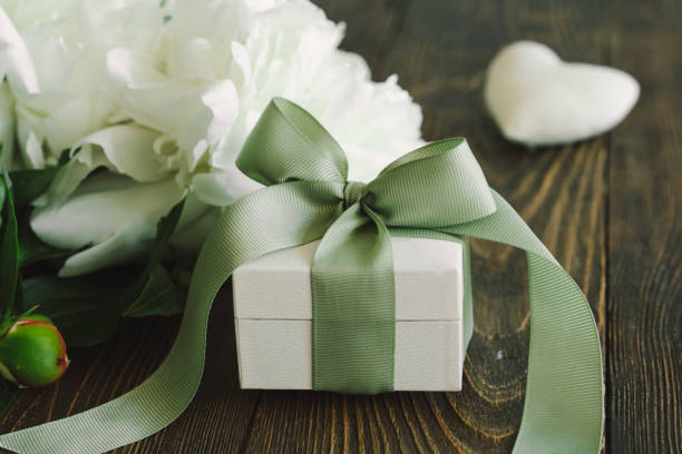 White gift box wrapped with green ribbon for a wedding gift.