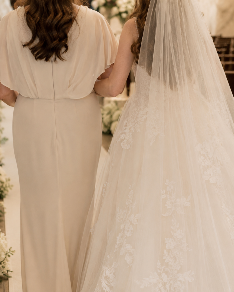 Up close shot of a mother walking her daughter down the aisle on her wedding day,