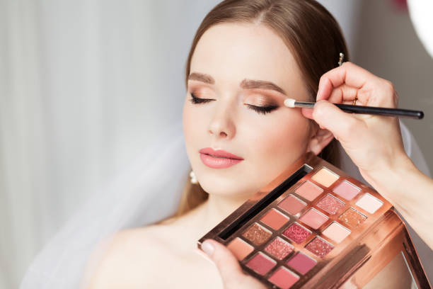 Bride getting her eyeshadow done on her wedding day.
